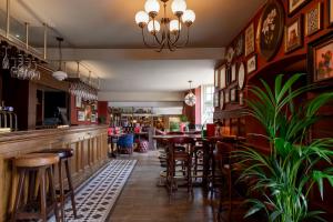 a bar with tables and stools in a restaurant at Red Lion Hotel in Radlett