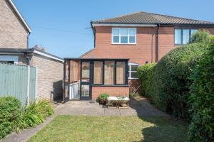 a brick house with a patio in front of it at Chestnutt Cottage, Reydon in Reydon