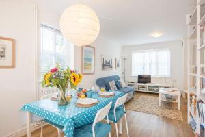 a living room with a blue table and a blue couch at Chestnutt Cottage, Reydon in Reydon
