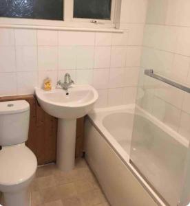 a bathroom with a sink and a toilet and a tub at Double room Eastbourne in Polegate