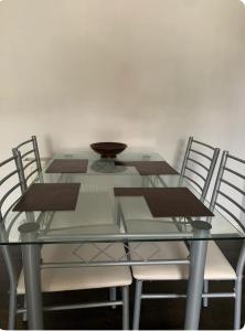 a glass table with chairs and a bowl on it at Double room Eastbourne in Polegate