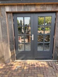 una porta di un edificio con un riflesso nelle finestre di B&B Buorren 5 a Herbaijum