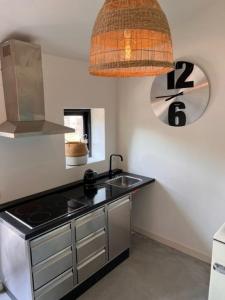 una cucina con piano cottura, lavandino e lampada di B&B Buorren 5 a Herbaijum
