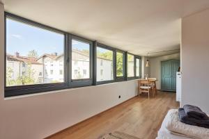 a room with large windows and a bed and a desk at Alte Seifensiederei - Lallaji in Bad Tölz