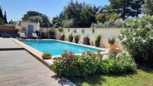 a swimming pool in a yard with flowers and plants at Maisonnette en campagne au calme in Carpentras