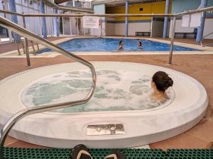 a woman in a hot tub in a swimming pool at RELAX en Vera Playa con SPA con Ventiladores de techo y aire acondicionado in Vera