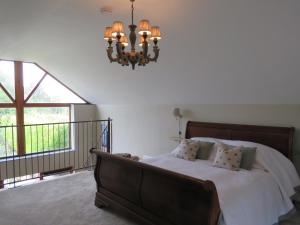 a bedroom with a bed and a chandelier at The Hayloft at Stathe Farm in Bridgwater