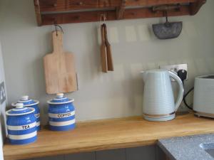 a counter with three blue and white jars and a vase at The Hayloft at Stathe Farm in Bridgwater