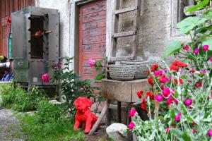 Ein roter Teddybär sitzt in einem Garten mit Blumen. in der Unterkunft Burghof Wallhausen in Konstanz