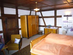 ein Schlafzimmer mit einem Bett, einem Stuhl und einem Waschbecken in der Unterkunft Burghof Wallhausen in Konstanz