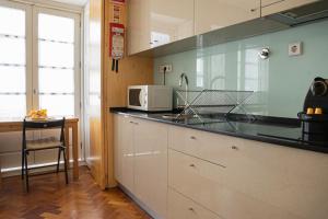 une cuisine avec un comptoir avec un micro-ondes dans l'établissement Impar Luxury Apartments, à Porto