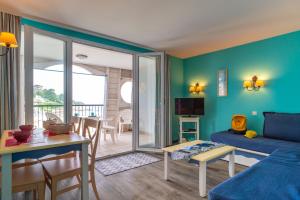 ein Wohnzimmer mit Sofa und Tisch in der Unterkunft Le Tamm Bara - Appt avec piscine partagée in Douarnenez