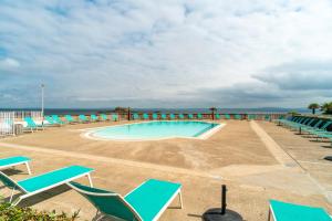 ein Swimmingpool mit Stühlen und das Meer im Hintergrund in der Unterkunft Le Tamm Bara - Appt avec piscine partagée in Douarnenez + 4 Fotos