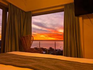 a bedroom with a window with a view of the ocean at Beachwood Camps Bay in Cape Town