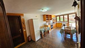 a kitchen with a refrigerator and a table and chairs at Casa Loaira do Casal in Moaña