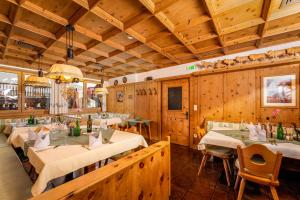 a restaurant with tables and chairs in a room with wooden walls at Alpen Wohlfühlhotel Dörflwirt in Hainzenberg