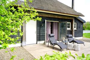 a patio with chairs and a house at Op 't Platteland in Haps
