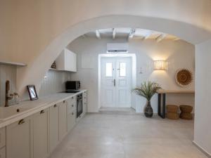 a kitchen with white cabinets and an archway at Katinas atelier in Kampos Paros
