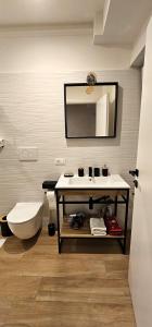 a bathroom with a sink and a toilet and a mirror at Lux Beach Apartment BLACK in Lido di Ostia +12 photos