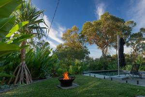 a fire pit in a yard next to a pool at Hilltop Hideaway at Coolum Beach in Coolum Beach