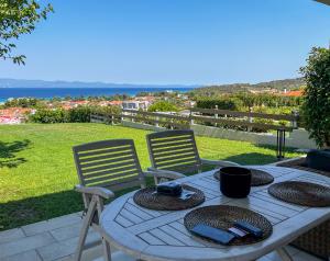 Una mesa y dos sillas con sombreros en un patio. en Villa Horizon Vista, en Chaniotis