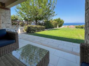 un patio con mesa, sillas y césped en Villa Horizon Vista, en Chaniotis