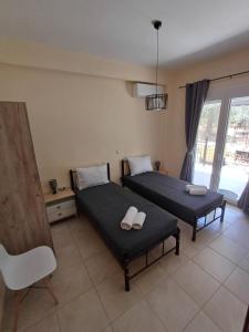 普里诺斯Vorgiashouse的有两张床、一把椅子和一扇窗户的房间