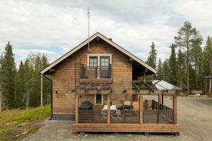 a log house with a porch and a balcony at Kurjenkenkä by HiYlläs in Kittilä