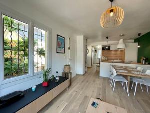 Una sala de estar con mesa de comedor y una cocina. en Rouen Gare - le Cabanon Grand Large, en Rouen