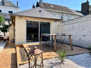 un patio con una mesa frente a una casa en Rouen Gare - le Cabanon Grand Large, en Rouen