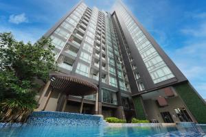 バンコクにあるThe Rich Residence Sukhumvit Nanaの正面にプールがある高層ビル