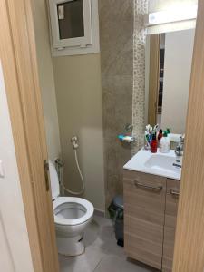 a bathroom with a toilet and a sink at appartement pour vacances avec piscine in Bouznika +4 photos