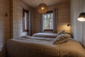 ユッラスヤルヴィにあるPiiponpirtti by Hi Ylläsのベッド2台とシャンデリアのある寝室
