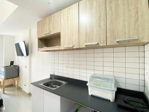 a kitchen with a sink and a counter top at Compact and Comfortable Studio Sayana Bekasi Apartment By Travelio in Bekasi