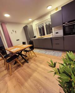 a large kitchen with a wooden table and chairs at Butas Ežero 30 in Plateliai
