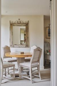 a dining room table with two chairs and a mirror at Lovedays Cottage, A Luxury 16th Century home in Painswick in Painswick