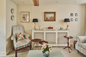 a living room with a couch and a chair and a table at Lovedays Cottage, A Luxury 16th Century home in Painswick in Painswick +77 photos