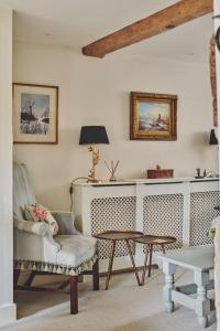 a living room with a chair and a table at Lovedays Cottage, A Luxury 16th Century home in Painswick in Painswick