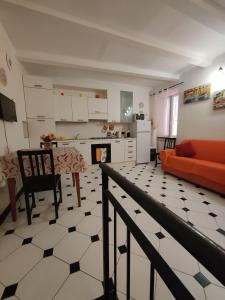 sala de estar con sofá naranja y cocina en Casa Manin, en Lavagna