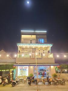 un edificio con moto parcheggiate di fronte ad esso di notte di Hoàng Thiện Homestay đảo Phú Qúy a Cu Lao Thu