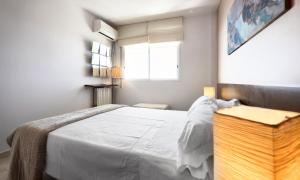 a bedroom with a large white bed and a window at Sitges Apartamente frente al mar con piscina in Sitges +30 photos