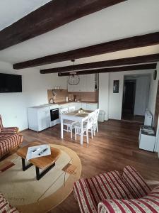 a living room with a table and a kitchen at Galoma Korana in Gornji Velemerić