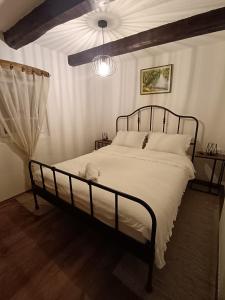 a bedroom with a large bed with white sheets at Galoma Korana in Gornji Velemerić