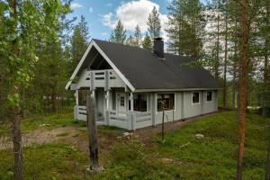 a white house in the middle of a forest at Rovankoto by Hi Ylläs in Ylläsjärvi