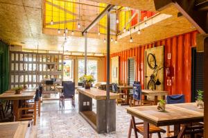 un restaurante con mesas y sillas de madera y techos coloridos en Alma Brava en Itajaí