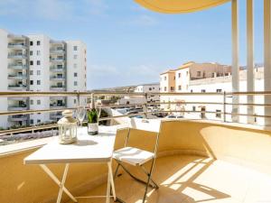 a balcony with a table and chairs on a building at Cozy Apartment Playa Paraiso, Pool in Playa Paraiso