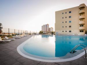 a large swimming pool next to a building at Cozy Apartment Playa Paraiso, Pool in Playa Paraiso
