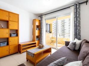 a living room with a couch and a large window at Cozy Apartment Playa Paraiso, Pool in Playa Paraiso
