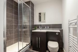 a bathroom with a toilet and a sink and a shower at Modern and Spacious Central Rotherham Studio in Rotherham