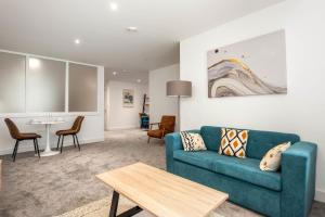a living room with a blue couch and a table at Modern and Spacious Central Rotherham Studio in Rotherham +7 photos
